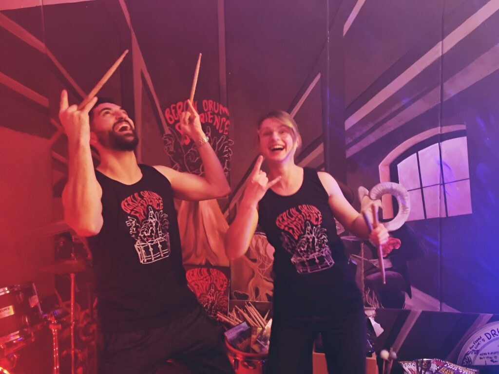 Two people sharing the energy of a BDE drumming experience