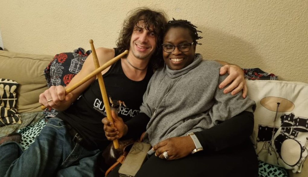 Marco and Kunbi holding drumsticks together at BDE