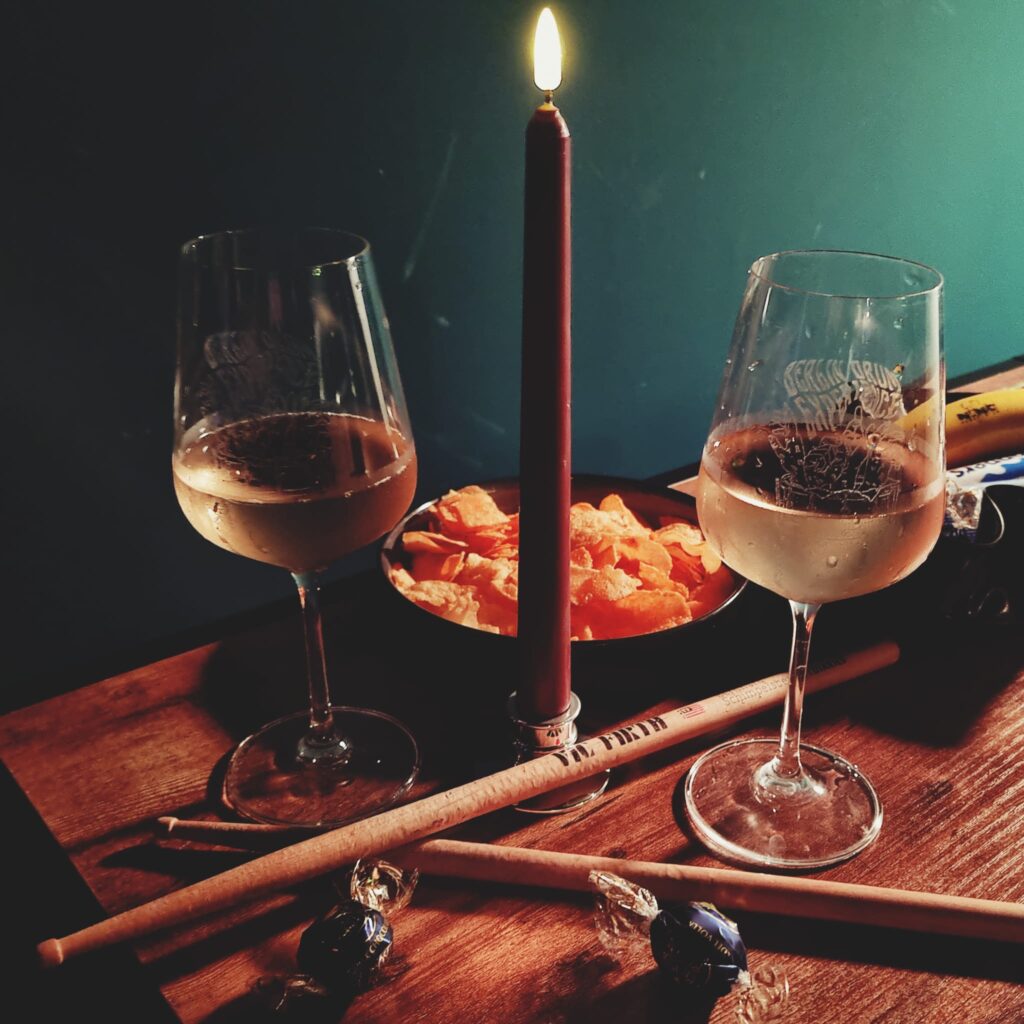 Two BDE wine glasses on a table with drumsticks