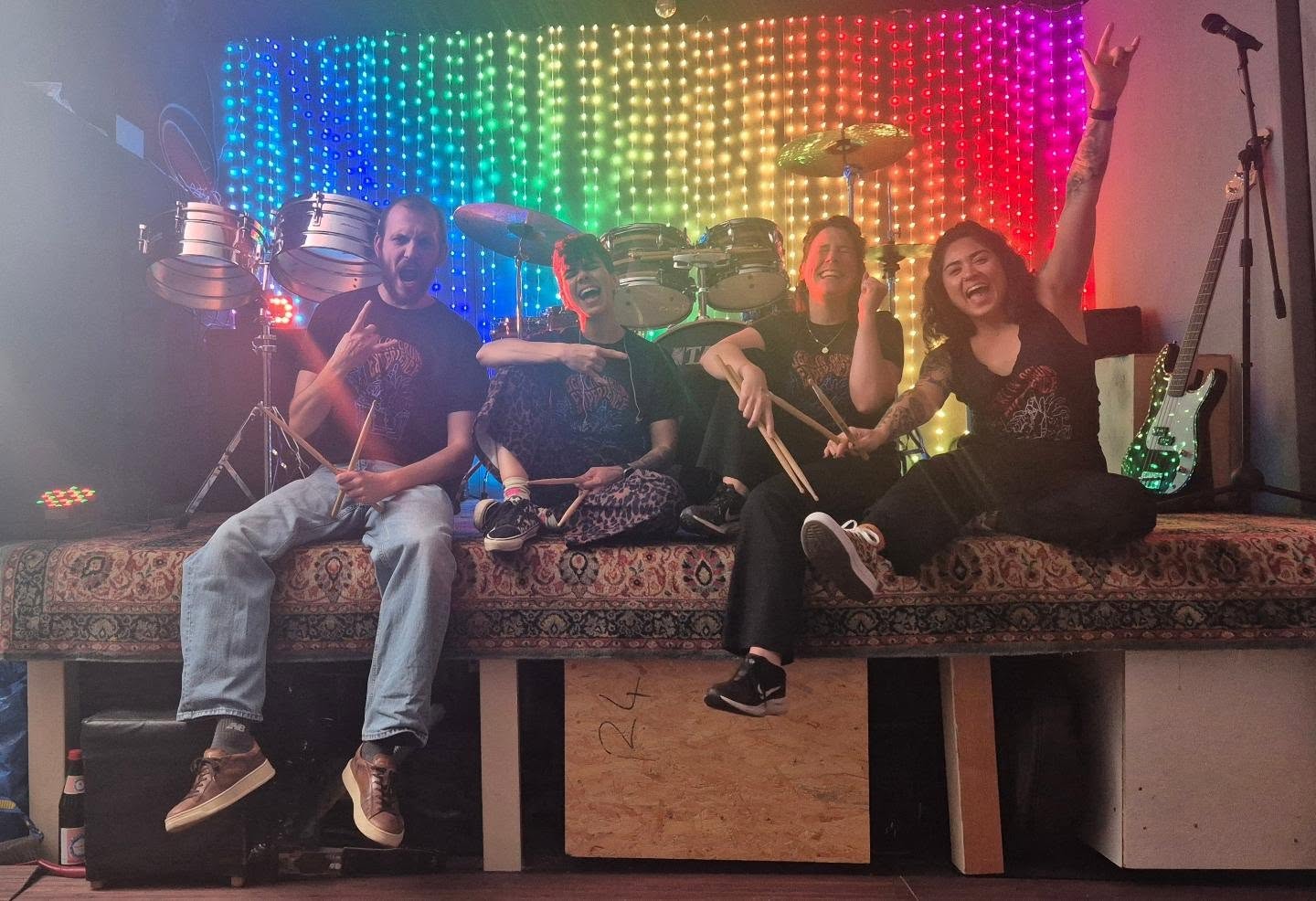 Four members of the Tribal Drum Ensemble with sticks in the colourful BDE Club