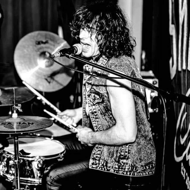 Marco Rivagli singing and drumming on stage