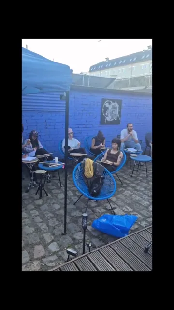 Drummers with practice pads in the blue-walled BDE courtyard